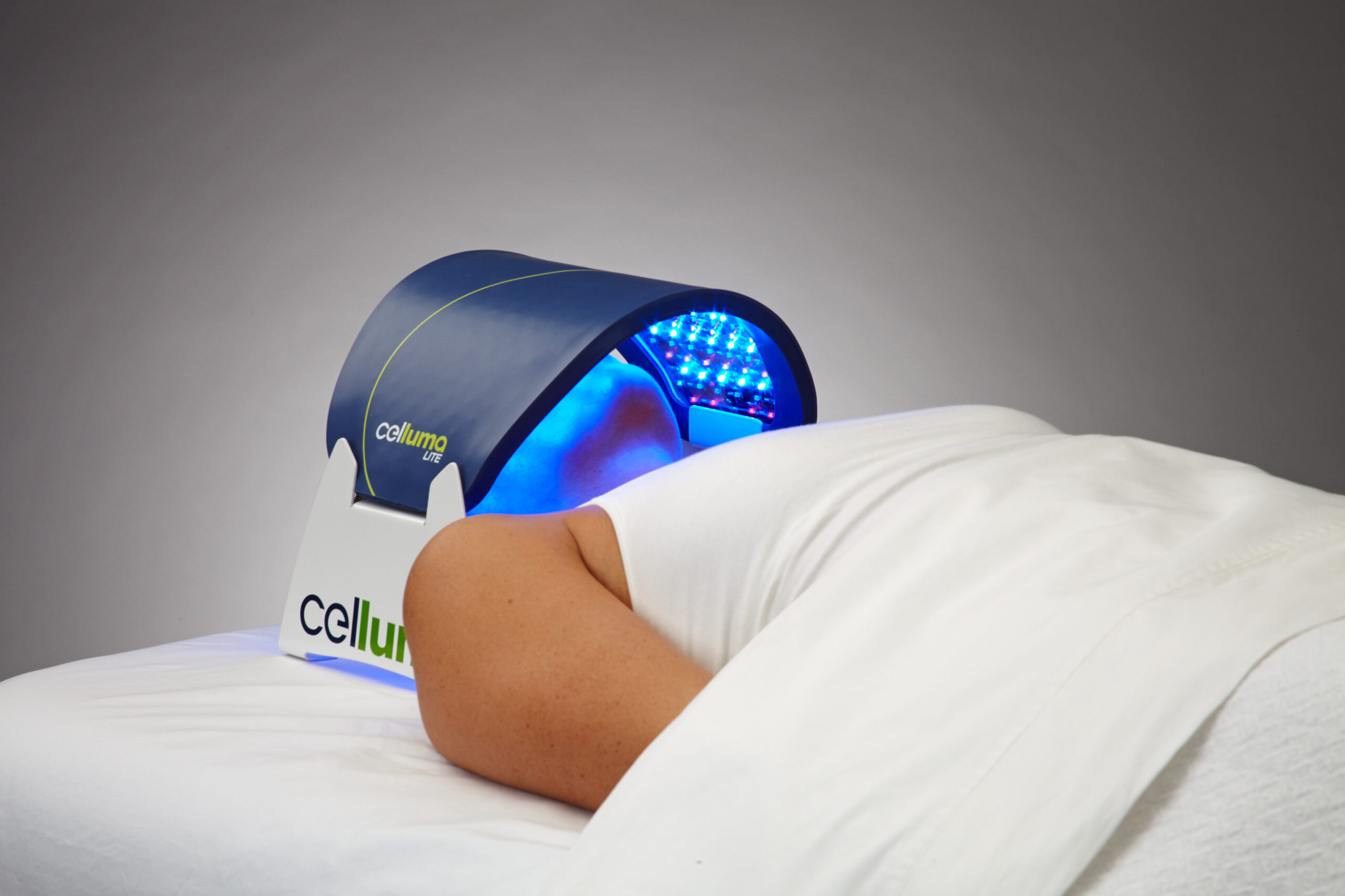 Celluma Lite in Acne mode on a person laying down. Celluma Lite over the face
